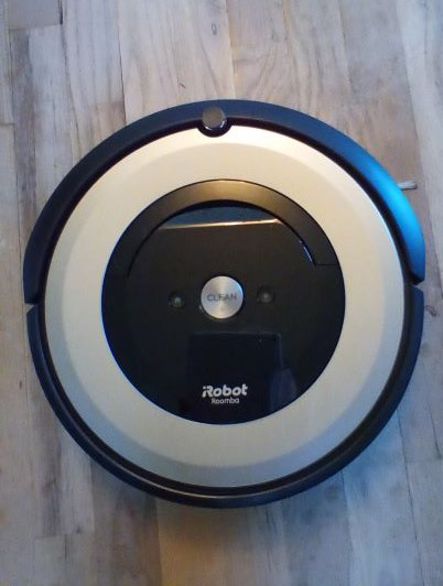 Roomba cleaning a cluttered living room